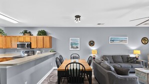 A modern kitchen with wooden cabinets, a built-in microwave, and a central island.