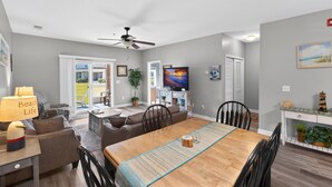 A dining area with a wooden table, chairs, and a ceiling fan.