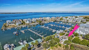 A marina with docked boats, a pier, and residential buildings.
