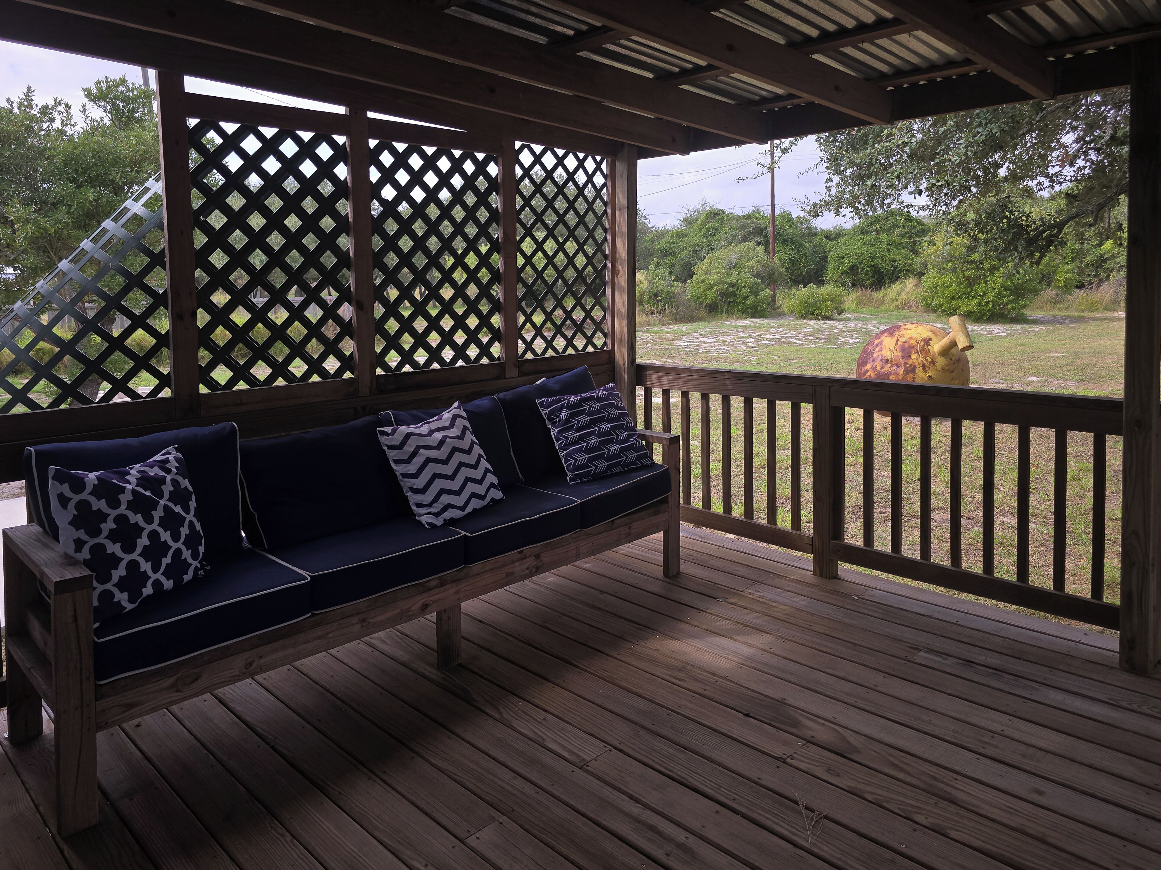 A wooden deck with a bench and lattice panels.