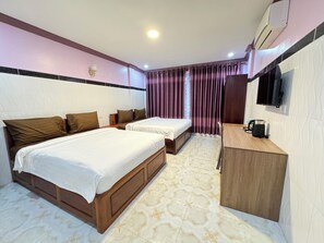 Une chambre d’hôtel avec deux lits, un bureau et une kitchenette.
