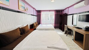 A hotel room with two beds, a desk with a TV, a window with curtains, and a city view. - The Cozy Corner-Budget Hotel (Kampot)