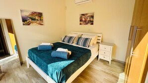Ein Schlafzimmer mit einem Bett, Nachttischen und zwei Wand-Klimageräten.