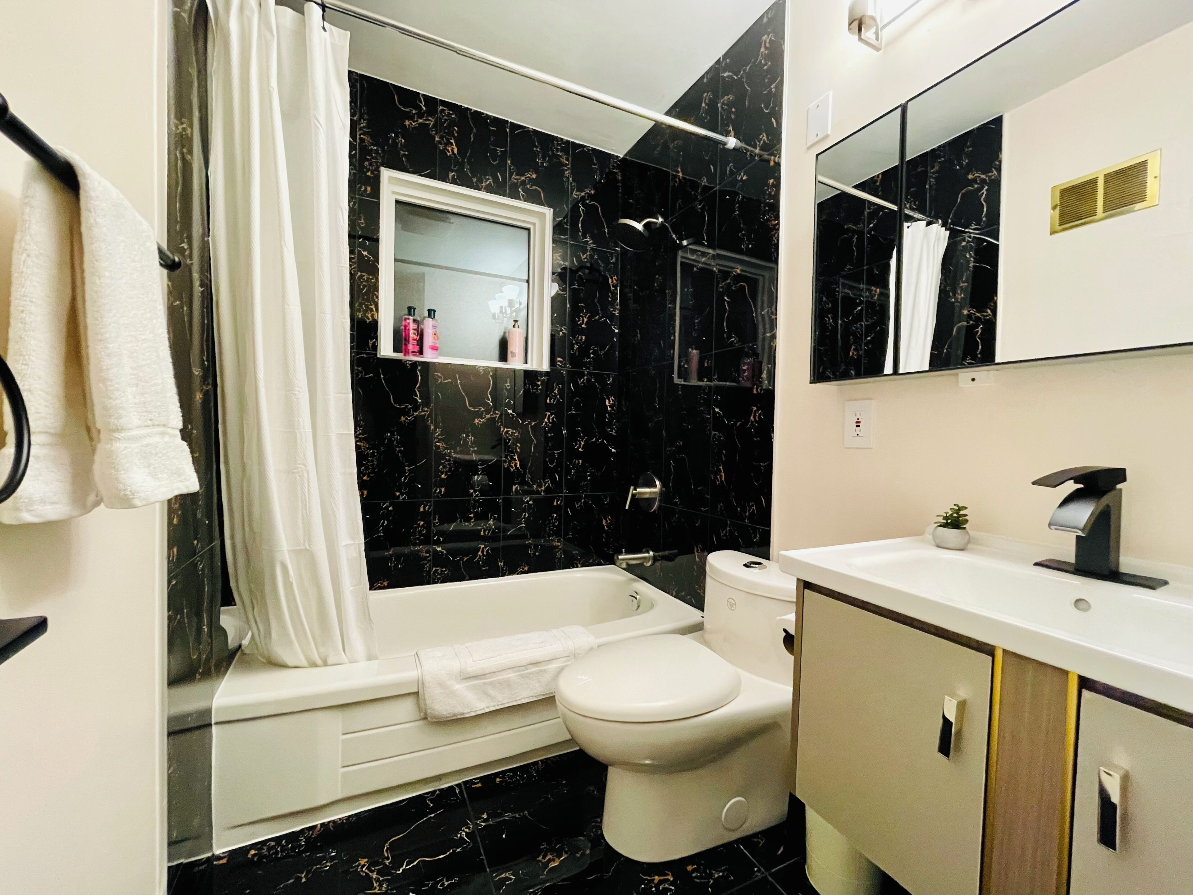 A modern bathroom with a bathtub, toilet, and sink.