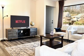 Smart-tv, een open haard, boeken en een computerscherm