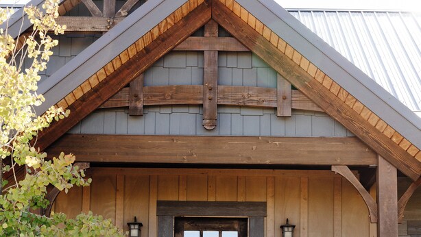 A rustic wooden building with a stone foundation, a wooden door with a window, and a stone staircase leading up to the entrance.