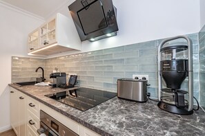 A modern kitchen with a built-in stove, a coffee maker, and a toaster.