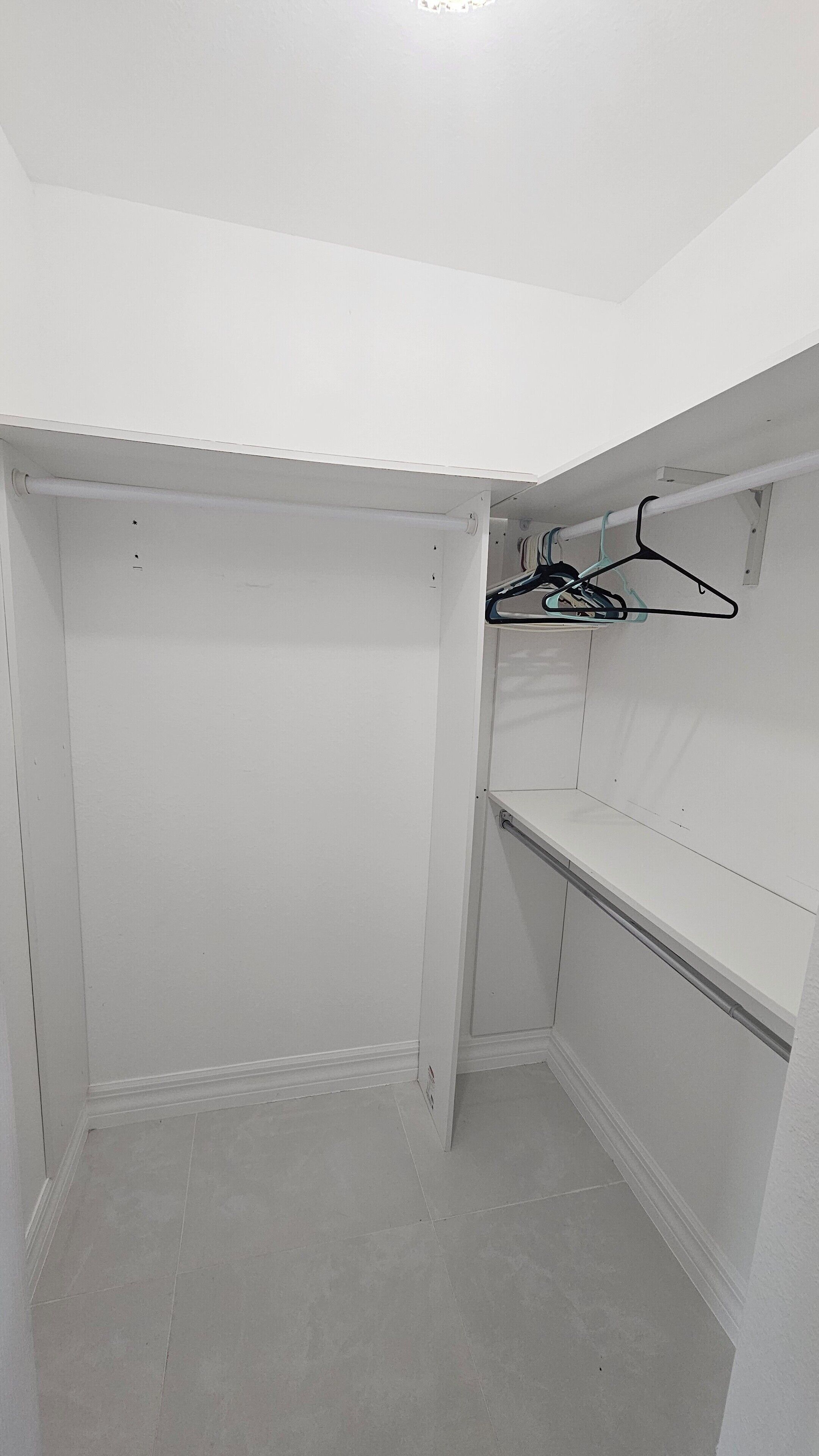 A white closet with a hanging rod and shelves.