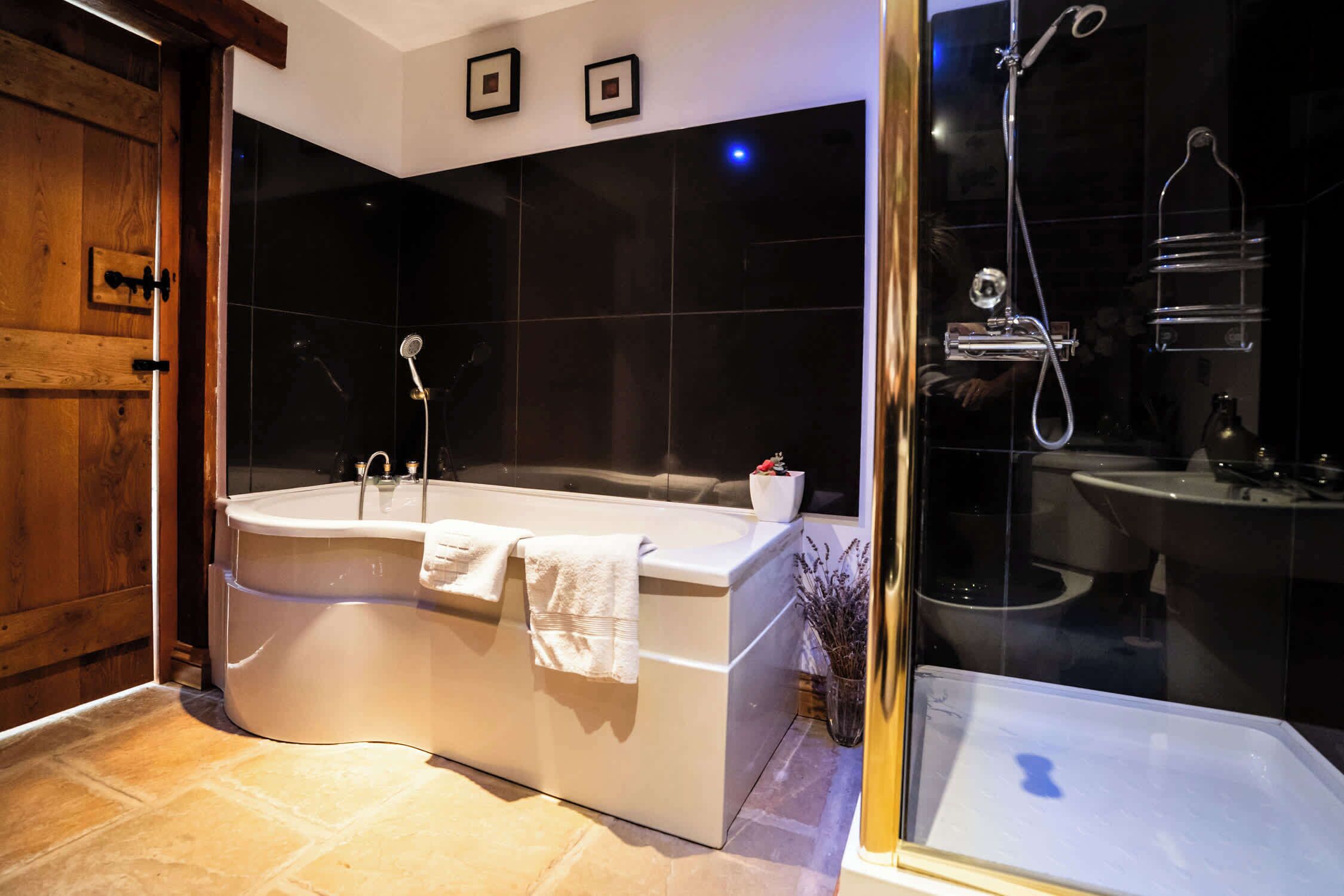 A modern bathroom with a freestanding bathtub, a glass-enclosed shower, and a large mirror.