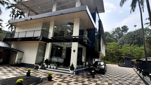 A modern building with a checkered floor, a balcony, and a car parked in front. - Evara Enclave Residency (Sullia)