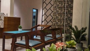 A spacious lobby with a reception desk, wooden chairs, and potted plants. - Evara Enclave Residency (Sullia)
