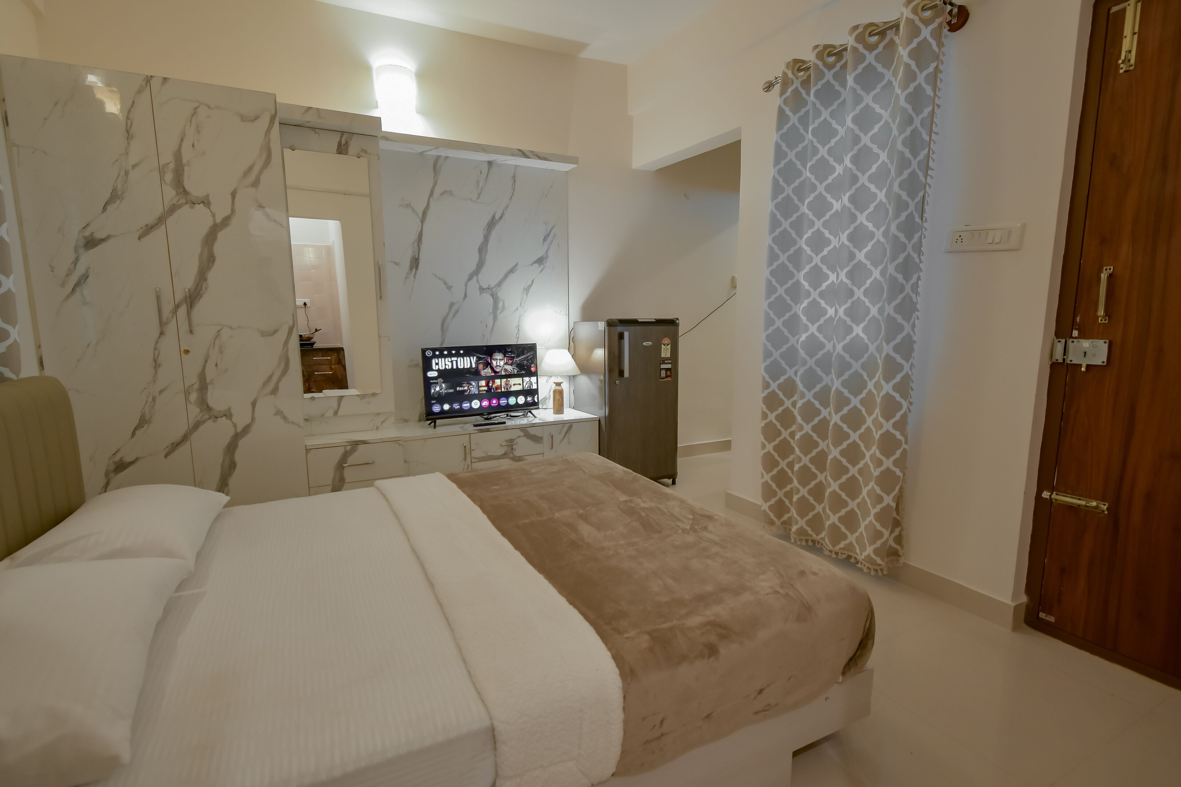 Une chambre d’hôtel équipée d’un lit, d’une télévision, d’une armoire et d’un rideau de douche.