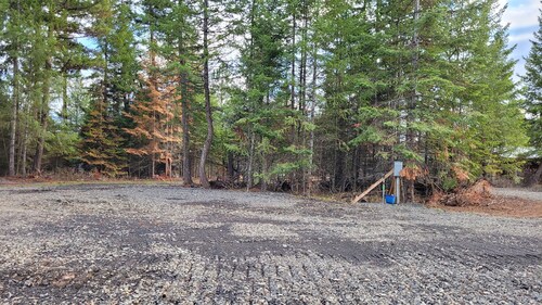 Large RV site with full hookups, surrounded by trees and nature.