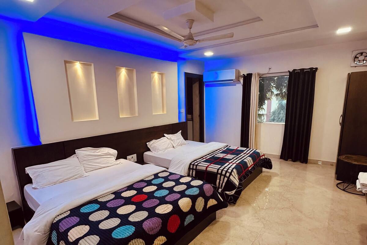 Une chambre d’hôtel avec un grand lit, un ventilateur de plafond, un éclairage encastré et une vue sur l’extérieur.