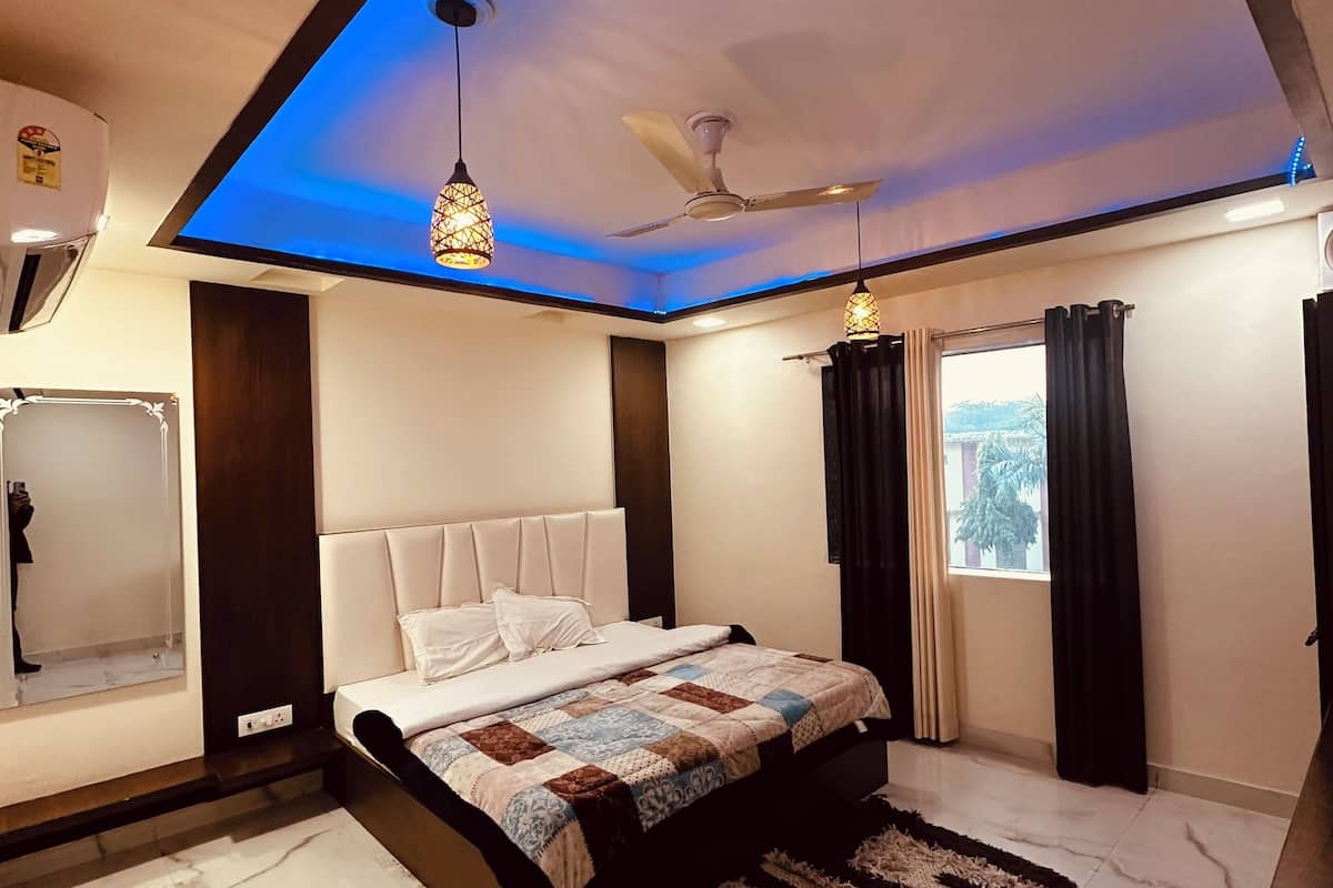 Une chambre à coucher moderne avec un lit, un ventilateur de plafond et une table de chevet.
