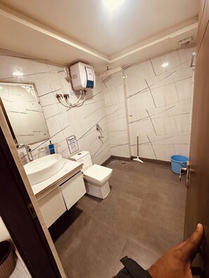 Eenvoudige tweepersoonskamer | Badkamer | Een douche, handdoeken, zeep, shampoo
