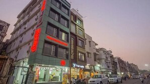 A multi-story building with various shops on the ground floor, including a visible pharmacy and a clothing store. - Hotel Vishnu Residency Inn (Amritsar)