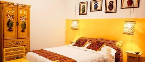 Um quarto com uma cama, uma cômoda de madeira e uma mesa de cabeceira.