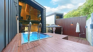 A modern outdoor pool area with a wooden deck, metal pool ladders, and a covered seating area. - Ulsan Byeoldam Eunchae Pool Villa (Ulsan)