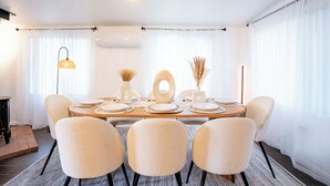 A dining area with a round table set for four, surrounded by four chairs.
