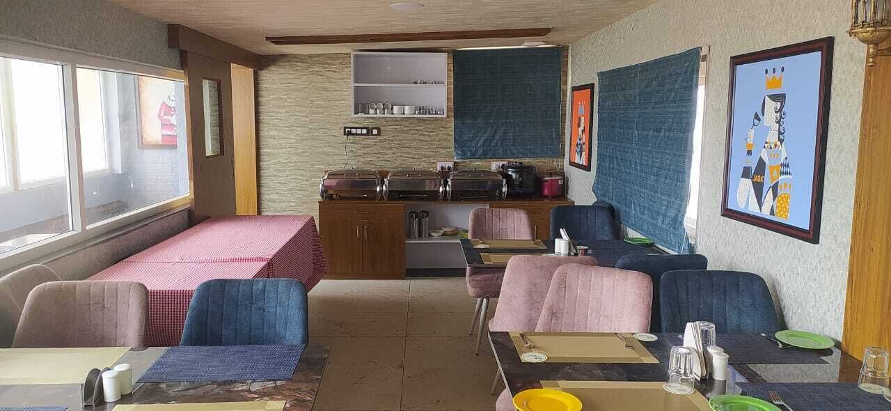 A dining area with a buffet setup, cushioned seating, and artwork on the walls.