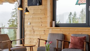 Un interior acogedor con paneles de madera, una mesa redonda y asientos cómodos.