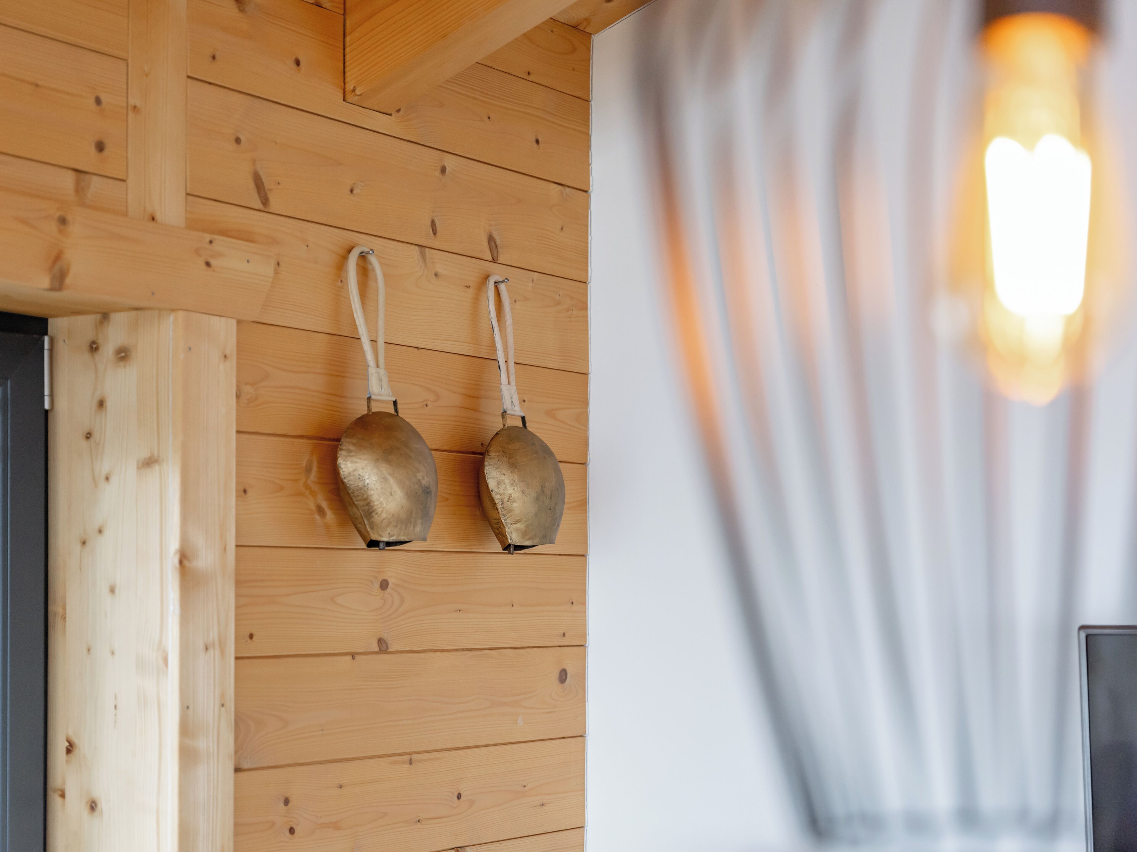 A wooden wall with two metal objects hanging.