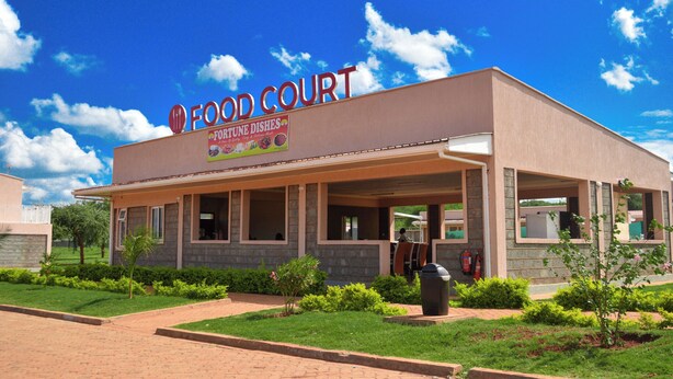 Un'area ristoro con un cartello che riporta 'FOOD COURT' e 'FORTUNE DISHES'.