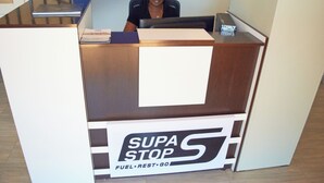 Una reception con un cartello che riporta la scritta "SUPA STOP FUEL REST GO".