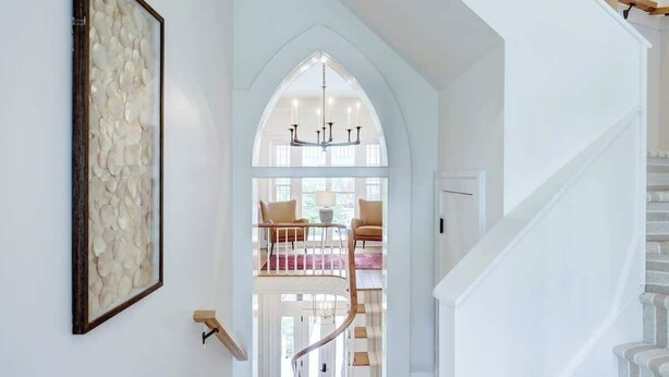 Eine Treppe führt zu einem Balkon im zweiten Stock mit Blick ins Freie.