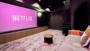 Una sala de cine en casa moderna con una pantalla grande mostrando 