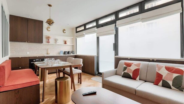 Un espacio de estar moderno con cocina, comedor y zona de descanso.