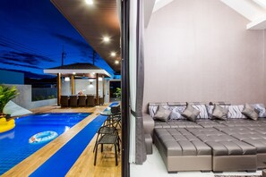 A modern interior with a pool, a seating area, and a large bed. - Baandomedoodao Pool Villa Cha-Am (Cha-am)