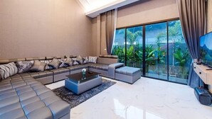 A modern living room with a sectional sofa, a coffee table, and a television. - Baandomedoodao Pool Villa Cha-Am (Cha-am)