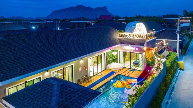 A modern hotel with a swimming pool, outdoor seating, and a view of mountains. - Baandomedoodao Pool Villa Cha-Am (Cha-am)