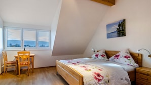 A bedroom with a bed, a desk, a chair, a nightstand, and a painting on the wall. - 'Room 1' with Shared Garden and Wi-Fi (Reichenau)