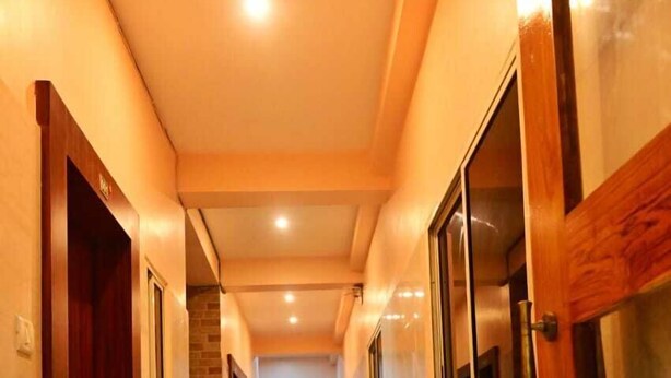 Un pasillo con puertas y ventanas de madera que conduce a una escalera.