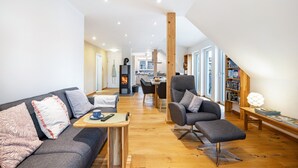 Una sala moderna con sofá, sillón, mesa de centro y estanterías.