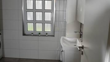 Kylpyhuone, jossa on ikkuna, pesuallas ja wc.