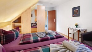 Ein Schlafzimmer mit Hochbett, einem kleinen Tisch mit einer Vase und einem Stuhl.