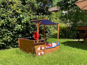 Una casita de juegos de madera con techo azul y un adorno de boia.