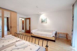 Una camera da letto con un letto, un divano, un armadio in legno e un piccolo tavolo.
