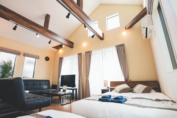 Ein Hotelzimmer mit einem großen Bett, einer Couch, einem Fernseher und einem Schreibtisch.