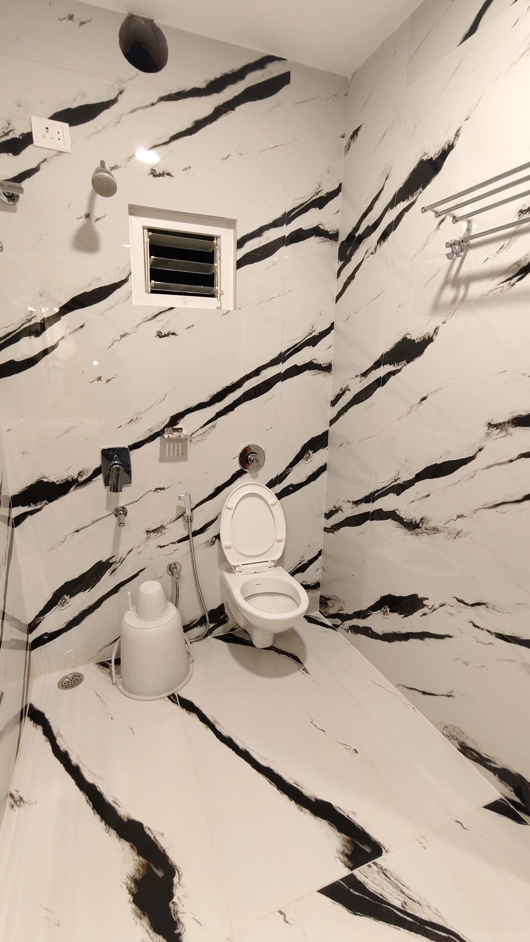 A bathroom with a toilet, bidet, and shower.