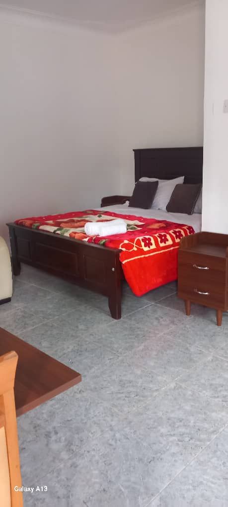 A bedroom with a bed, bedside table, and a chair.