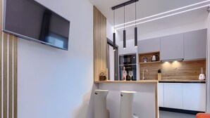 A modern kitchen with a flat-screen TV, pendant lights, and a wooden countertop. - Apartment Cintya by Interhome (Poreč)