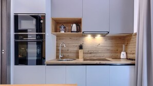 A compact kitchen with a Bosch microwave, a built-in oven, a sink, and a countertop with a coffee maker and a blender. - Apartment Cintya by Interhome (Poreč)