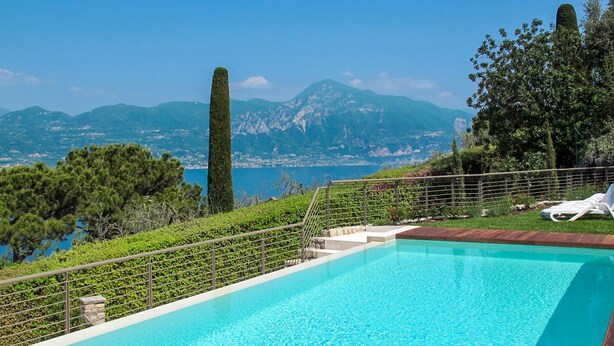 A swimming pool with a view of mountains and the sea.