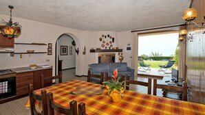 A dining area with a plaid tablecloth, wooden chairs, and a central floral arrangement.