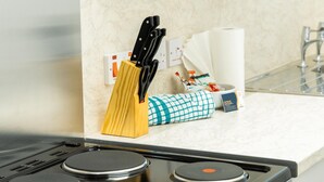 A kitchen counter with a knife block, a towel, and a roll of paper towels. - Court Street by Central Serviced Apartments (Dundee)